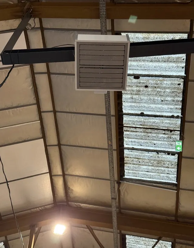 Vue rapprochée d’un déstratificateur suspendu dans un bâtiment professionnel