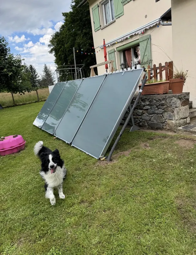 Capteurs solaires thermiques inclinés sur châssis devant une maison